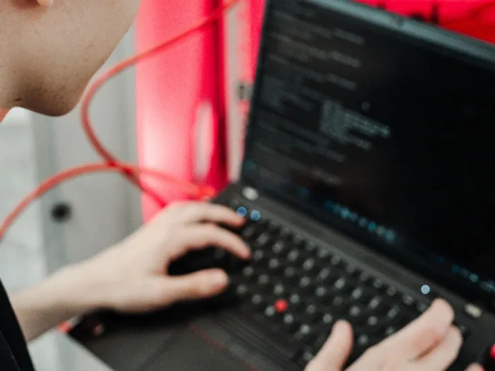 IT-Techniker arbeitet an einem Laptop mit Netzwerkkabel